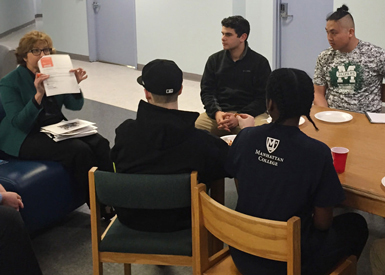 students and faculty talk at table