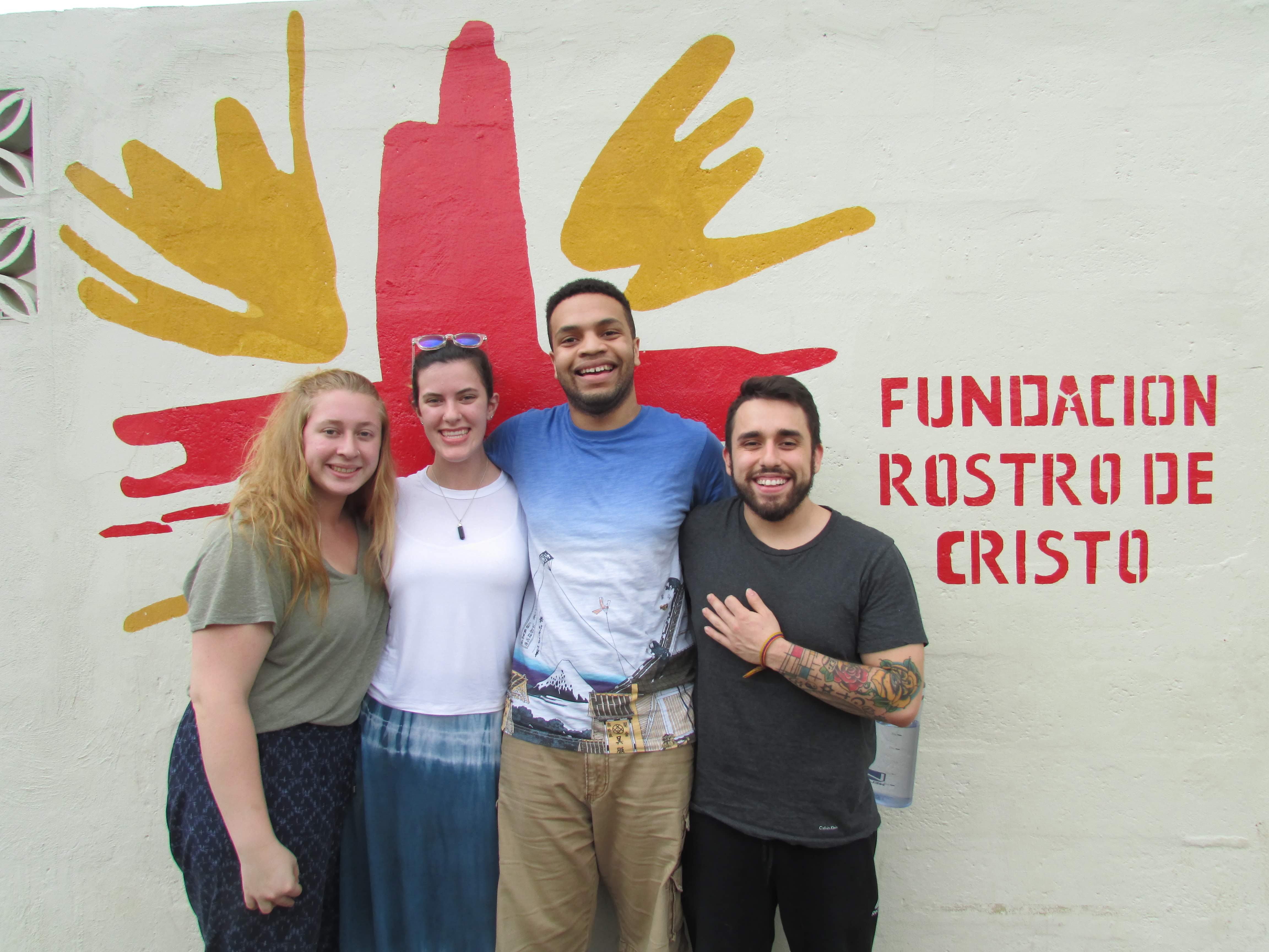 group of students posing in front of a fundacion rustro de cristo sign