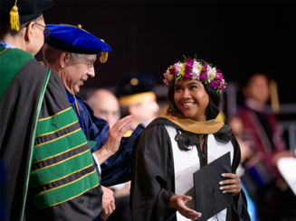 Photo of female student being hooded by Dean Donald Gibson