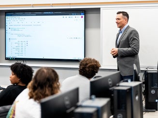 Manhattan University professor teaching in a business classroom