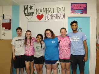 students stand together under a sign that reads "Manhattan Homestead"