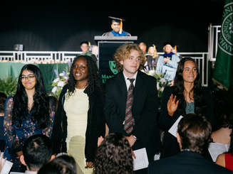 Students are recognized on stage during Spring Honors at Manhattan University as faculty and classmates celebrate their achievements.