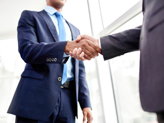 two people in business suits shake hands