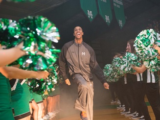 a basketball player walks between rows of cheerleaders