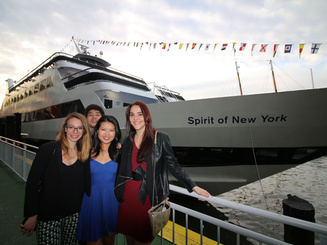 four students pose in front of a cruise ship at dock