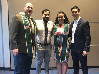 four people standing together at an honoring event
