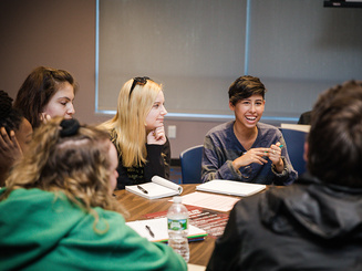people have a discussion around a table at a conference