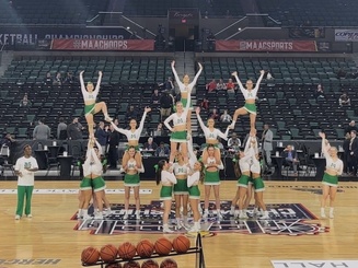 Manhattan University cheerleaders performing on a basketball court