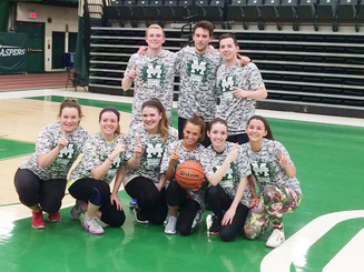 a co-ed intramural basketball team poses on the basketball court