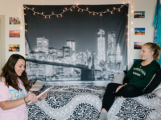 two students talk while in a dorm room