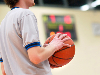 a person holds a basketball on a playing court