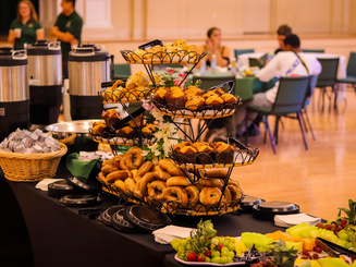 breakfast food and drink on a long buffet table in a dining hall