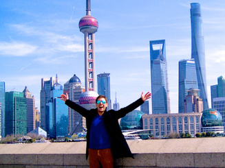 Student posing in front of the Shanghai skyline during a study abroad experience.