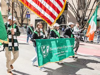 Manhattan University alumni carry the University banner and flags during the New York City St. Patrick’s Day Parade