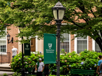 Manhattan University campus looking at one of the Manhattan flags on a light pole