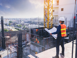 Civil architect engineer inspecting and working outdoors building side with blueprints. engineering and architecture concept.