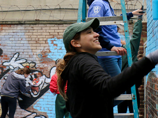 Students and community members paint a wall
