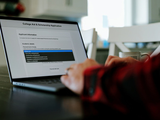 person sitting at a laptop filling out financial aid information