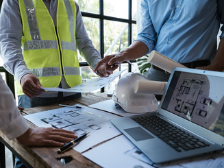 Close up of hands working and brainstorming on paperworks and floor plan drawings about design architectural and engineering for houses and buildings.