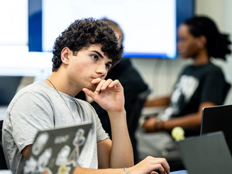 Manhattan University student focusing during a lecture