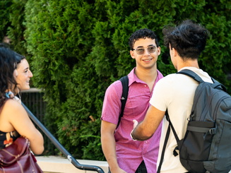 Manhattan University students smiling talking outside on the Quad