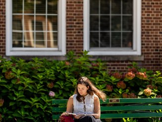 Manhattan University student smiling sitting outside studying