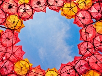 colorful umbrellas arranged as a canopy under a blue sky