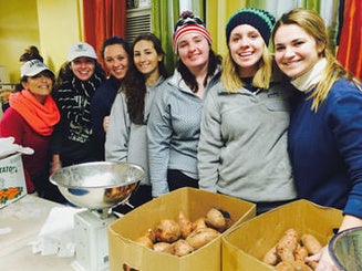 students help prepare and pack food as part of a weekly service event
