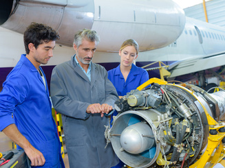 Students and professor doing an inspection of aircraft part
