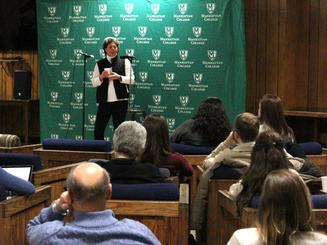 A speaker on a podium as part of the Agape Latte Speaker Series