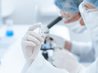 A close up ampoule with a new vaccine in the hands of a scientist