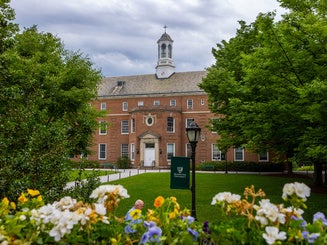 Picture of the Quad and Memorial Hall in the Summer with flowers.