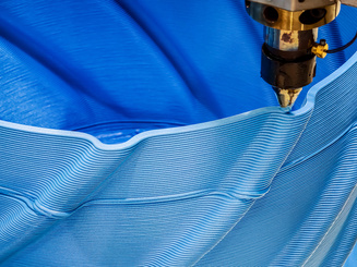 Advanced 3D printing process creates intricate blue patterns in a flexible material on a production line