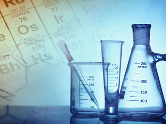 set of beakers with a periodic table in the background
