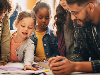 Students doing a creativity project with their teacher in a classroom