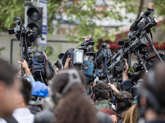 people standing in a group with cameras for a press conference