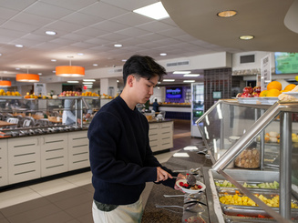 Manhattan University student eating in one of the dining halls