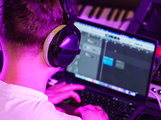 Student Focuses Editing Track with Headphones On
