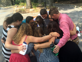 group of people in a circle praying