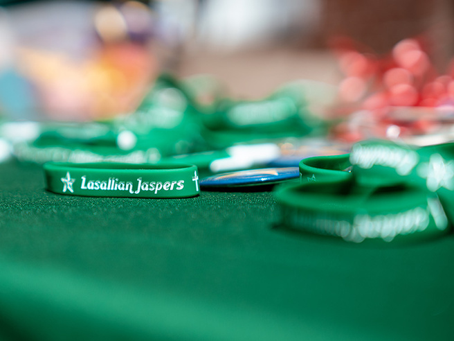 Green ‘Lasallian Jaspers’ bracelet displayed on a table during a Manhattan University mission event.