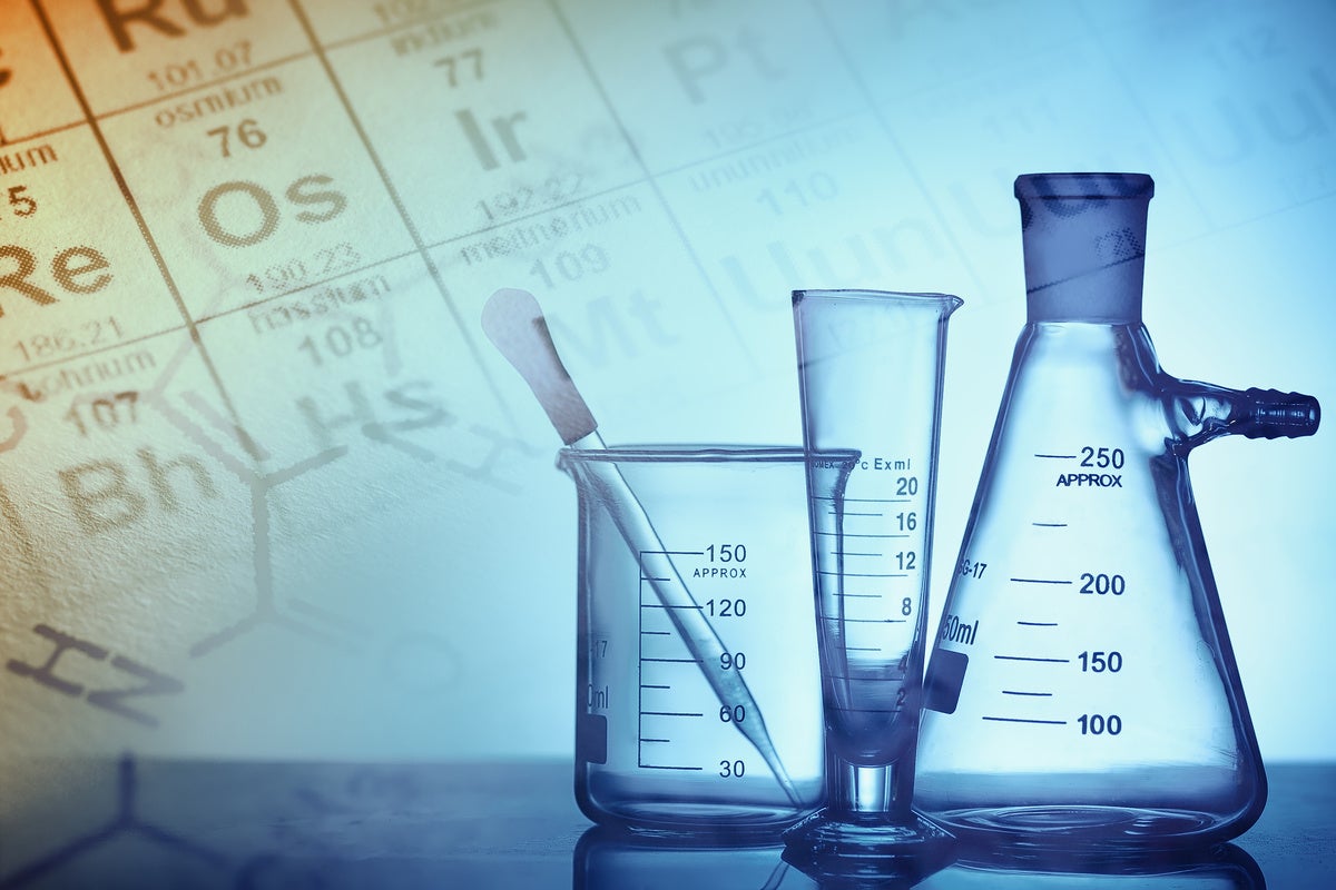 set of beakers with a periodic table in the background