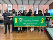 Photo of Manhattan University Student Veterans In the Veterans Success Center holding a Manhattan University banner