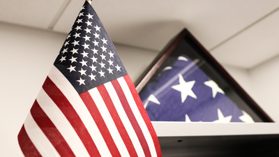 The flag of the USA, hanging near a boxed, folded American flag