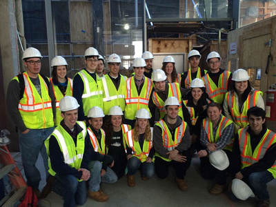 members of the American Society of Civil Engineers gather wearing vests and hard hats