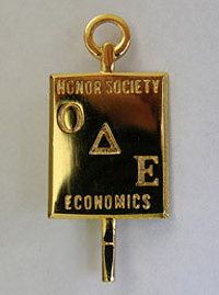 A pin of the emblem for the Omicron Delta Epsilon honor society