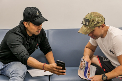 two veterans look at a phone together