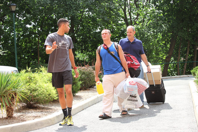 A new student is guided to their residence hall on move-in day