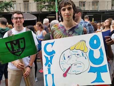 students hold signs at an outdoor event