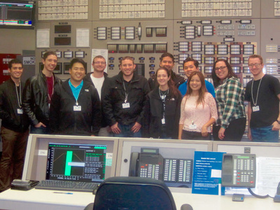group members stand inside a power control station