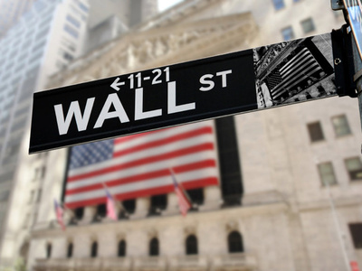 The Wall Street street sign with a city building in the background